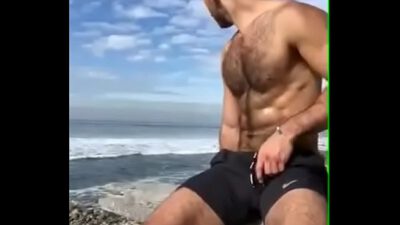 Gostoso batendo punheta na praia